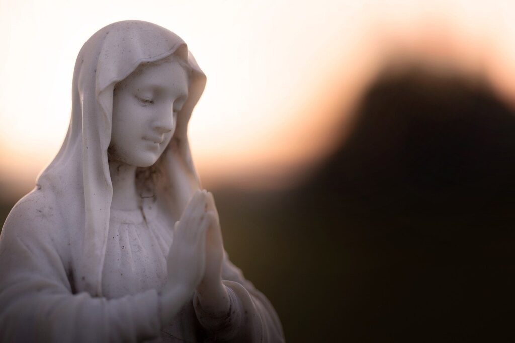 Estatua de la Virgen María en oración al atardecer